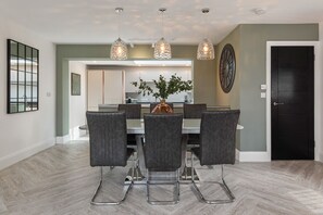 A dining area with a table, chairs, and pendant lights. - No5 Highpoint luxury townhouse ,2 en-suite bedrooms onsite indoor swimming pool (Saundersfoot)