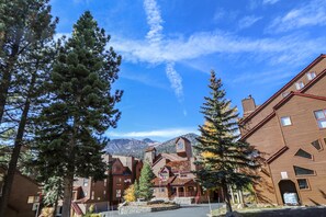 Stunning hotel with a traditional central building and clock tower, set amidst mature trees and breathtaking mountain views.
