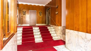 A grand staircase with red carpet, wooden paneling, and marble steps. - 2 Bedrooms Apartment in the City Center (Milan)
