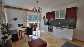 A compact living space with a dining area, kitchenette, and a sofa.