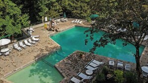 A pool area with multiple sun loungers, a slide, and a small table with chairs.