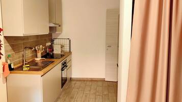 Eine moderne Küche mit weißen Schränken, einer Holz Arbeitsplatte und einem Edelstahl-Spülbecken.