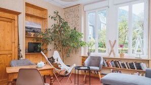Una habitación acogedora con un aparador de madera, un televisor, una mesa de comedor y una estantería llena de libros.
