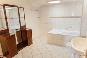 A bathroom with a glass-enclosed vanity, a freestanding bathtub, a toilet, and a sink. - Ferienwohnung Bischoff (Winnweiler)