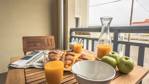 A wooden table with croissants, apples, a glass of orange juice, a glass of orange juice, a newspaper, and a white bowl. - Cozy apartment offering an exceptional location - 1st sea line - swimming pool (Biscarrosse)