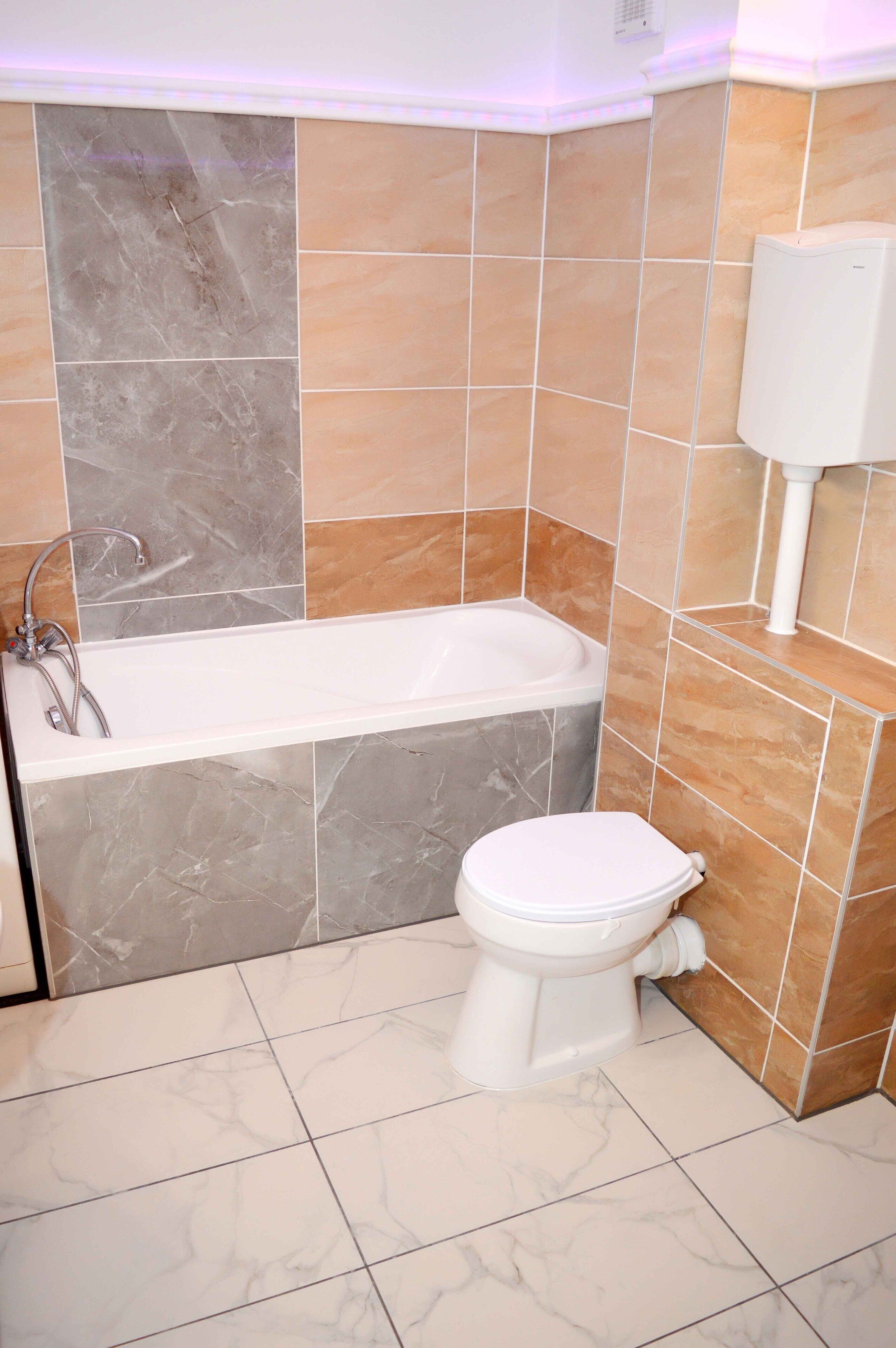 Un baño con bañera, inodoro y zona de ducha.