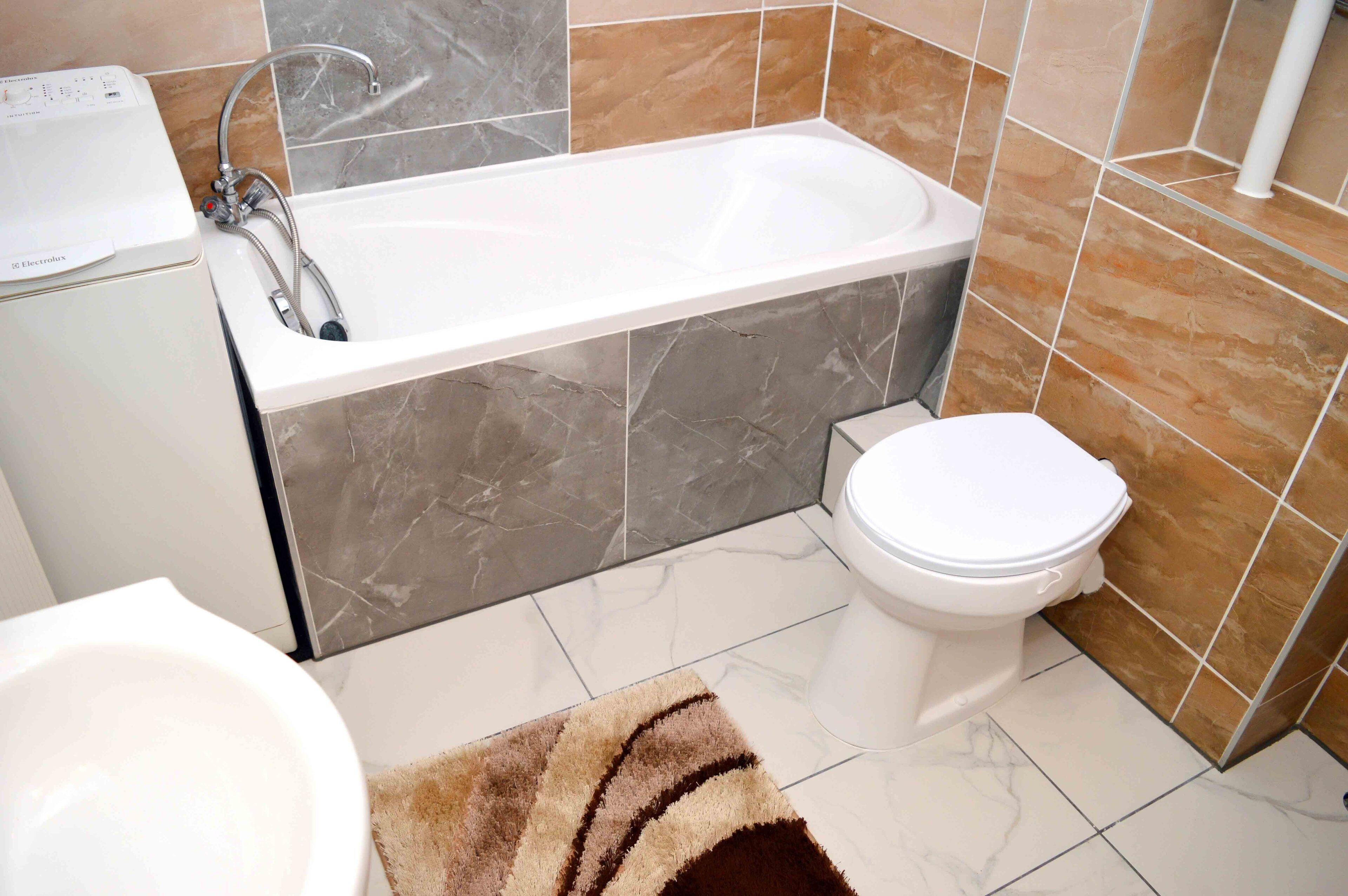 Ein modernes Badezimmer mit Badewanne, Toilette und Waschbecken.