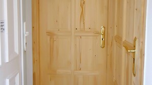 A wooden door with a brass handle and a white door frame. - Lorabel Apartmanház Hévíz (Hévíz)