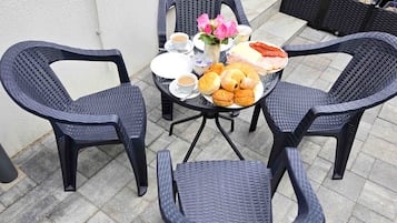 Una mesa dispuesta con sillas, platos de comida y una taza de café.