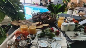 A breakfast setup with bread, orange juice, and various spreads on a tray. - Desir'Add (La Clisse)