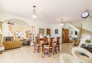 A spacious living room with a dining area, a fireplace, and a staircase. - Villa Casa Tomise with private swimming pool and fantastic views (Salobreña)