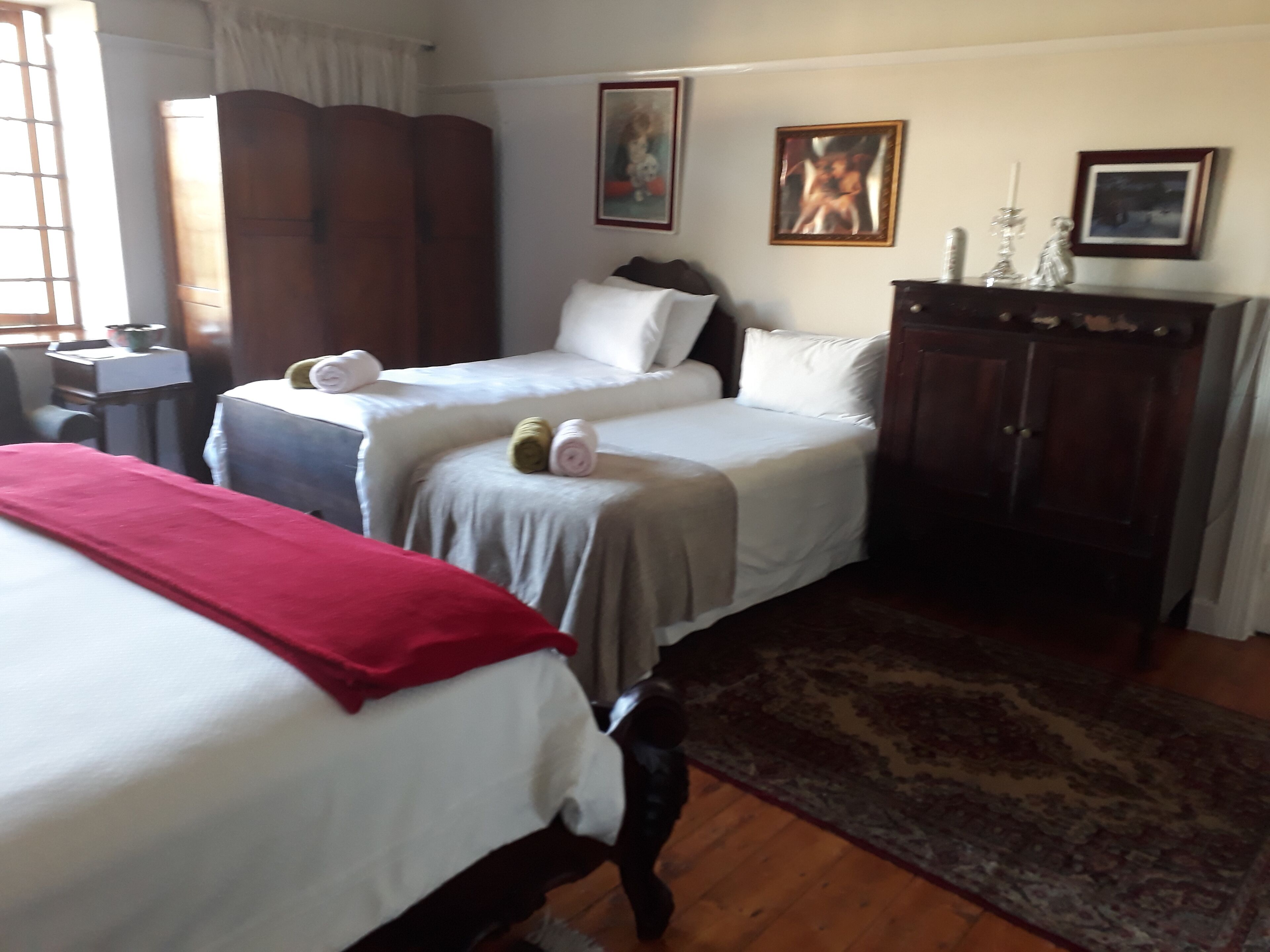 Une chambre d’hôtel avec deux lits, une armoire et un bureau.