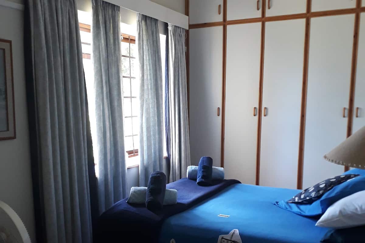 A room with a bed, a desk, and a wardrobe.
