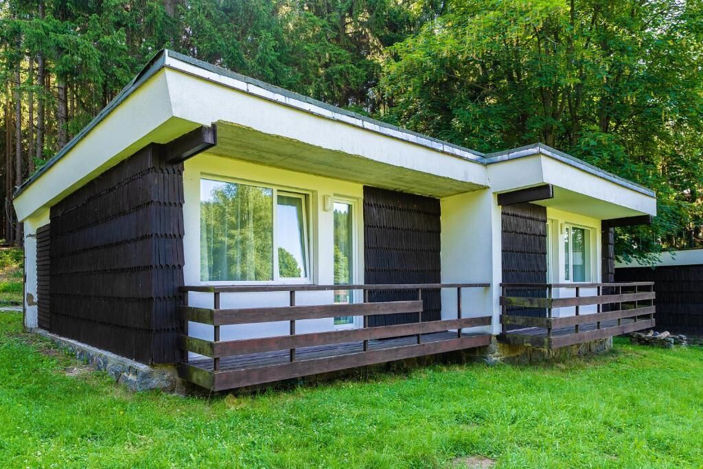 Deux cabanes dotées d’un toit en pente, de grandes fenêtres et d’une terrasse en bois.