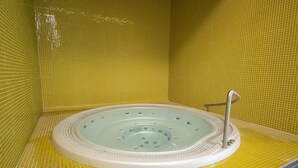 Una vasca idromassaggio dalla forma circolare, circondata da pareti piastrellate di giallo.