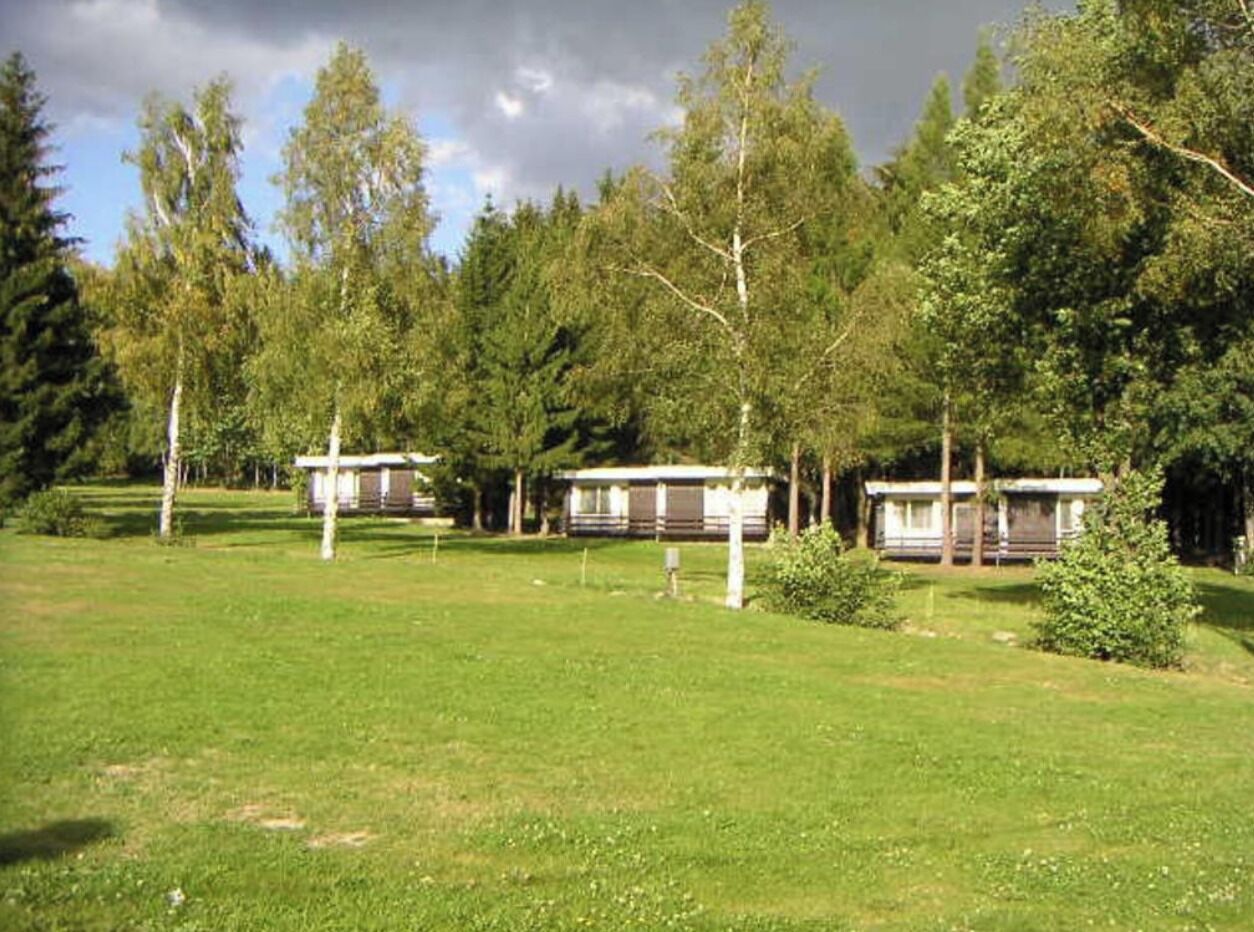 En campingplads med campingvogne og en græsplæne.