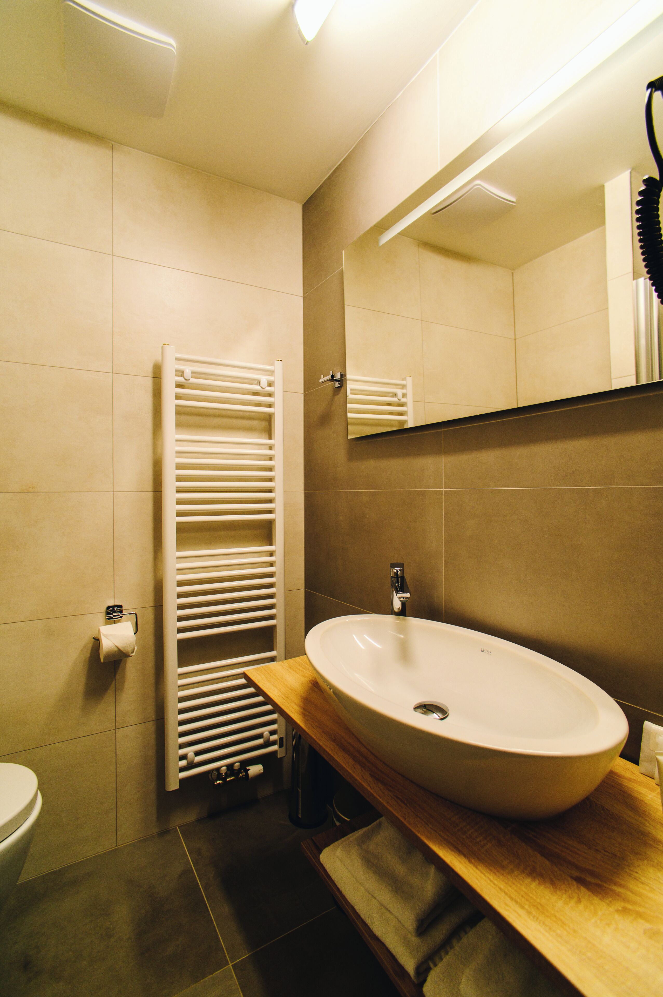 A bathroom with a white sink, a mirror, and a towel rack.