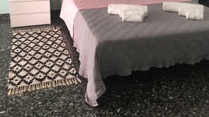 A bedroom with a bed, two bedside tables, a rug, and a painting on the wall. - Lorenzo House Venice Mestre (Venezia)
