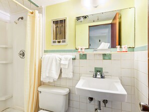 A bathroom with a toilet, sink, and shower. - OYO Hotel Downtown Peoria I-74 (Peoria)