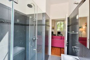 Enjoy a refreshing shower in the glass-enclosed shower with a handheld showerhead and separate sink.