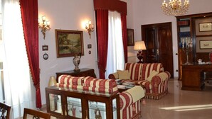 Una habitación tradicional con un conjunto de sofá, una mesita de madera, una araña y una estantería.