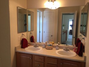 A bathroom with two sinks, a mirror, and a light fixture.