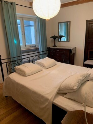 A bedroom with a bed, a dresser, a mirror, and a window with curtains. - Detached cozy family home with pool and beautiful views (Saint Vincent d'Olargues)