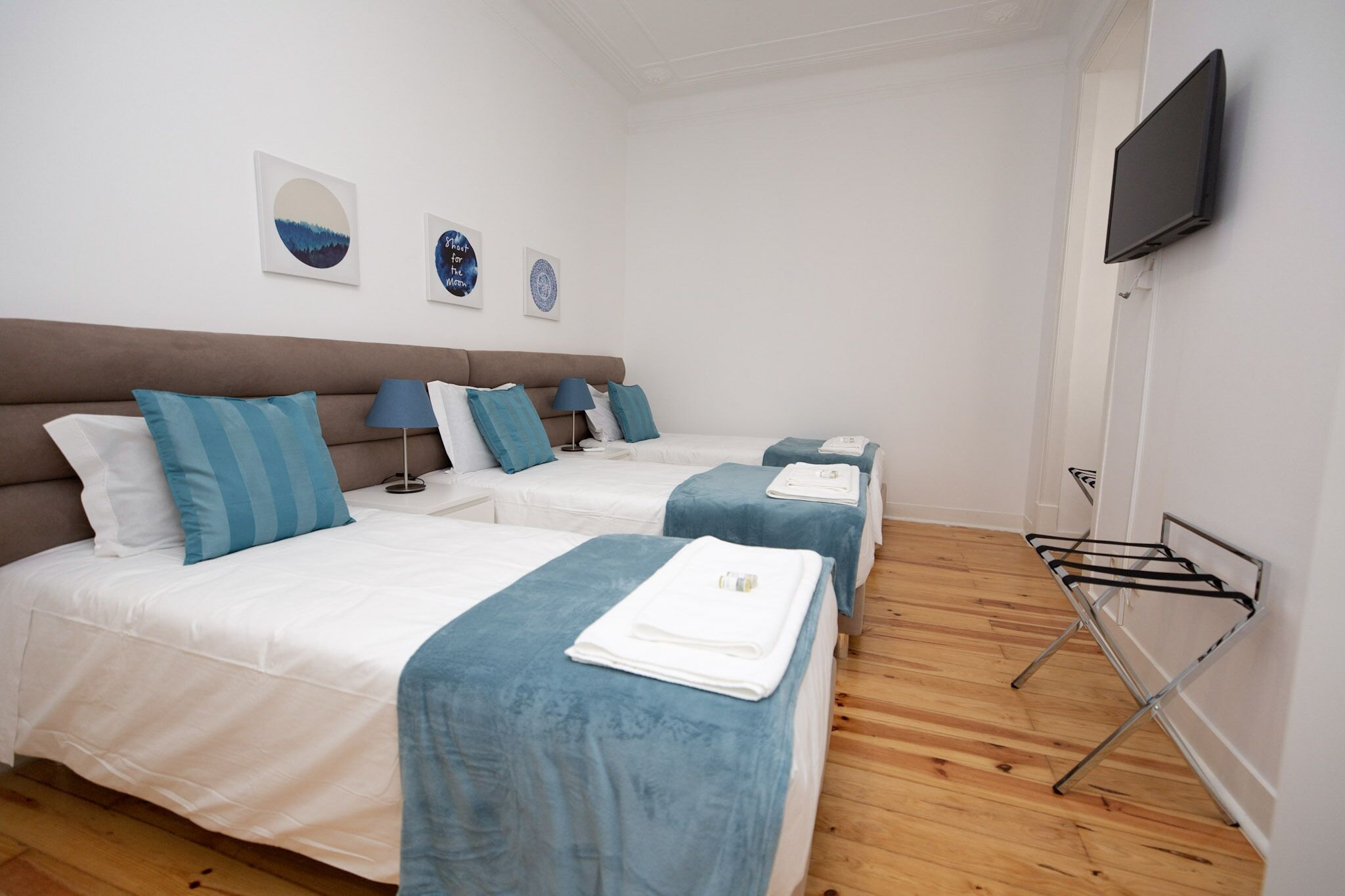 Habitación de hotel con dos camas, un televisor y un tendedero.
