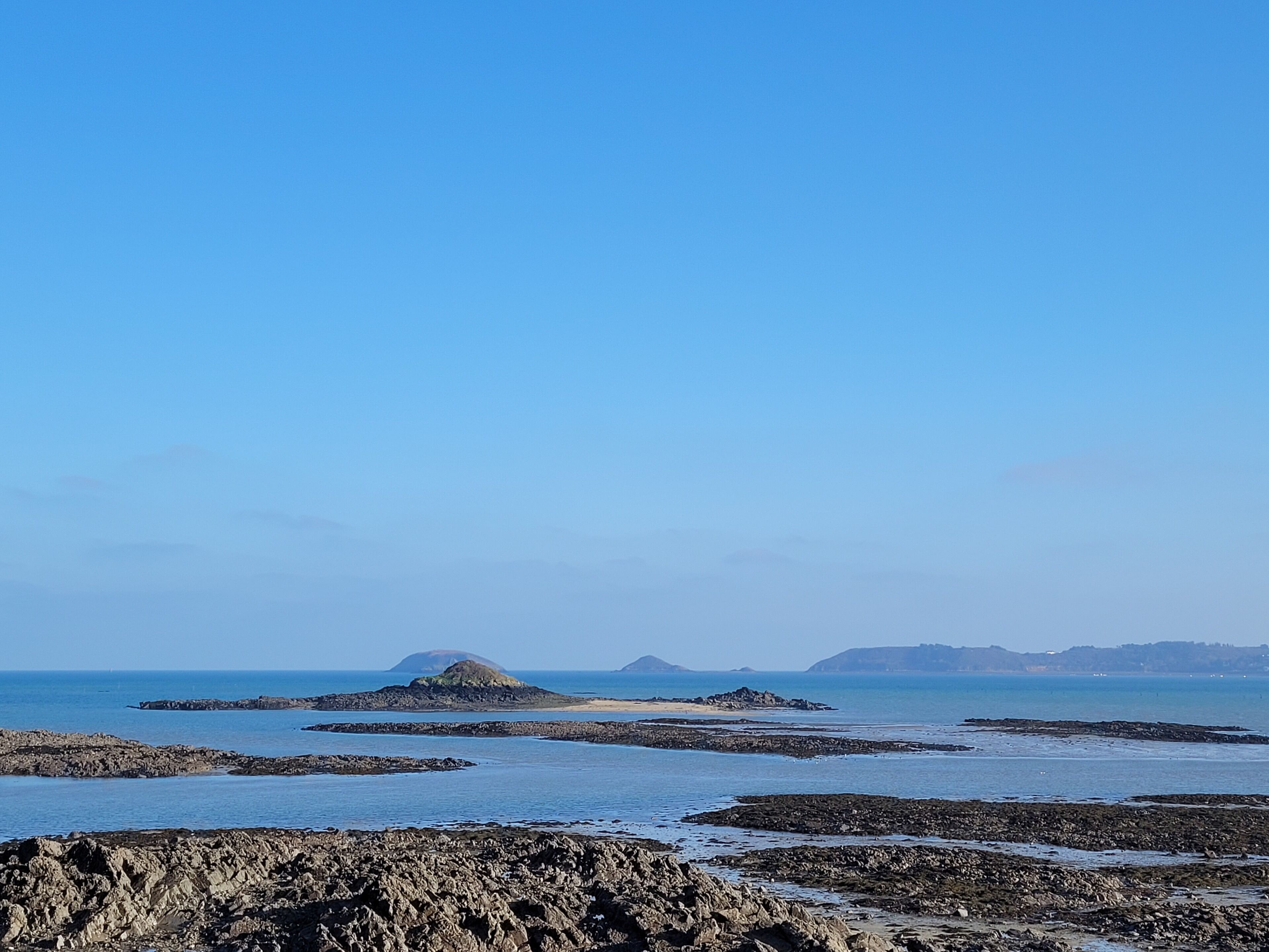 A rocky coastal landscape with clear skies.