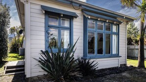 A small, single-story building with a gabled roof and large windows. - Oroua Cottage - Rangataua Bach (Ohakune)