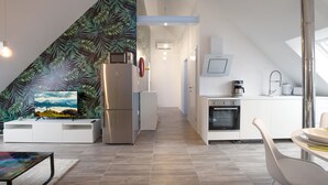 Eine moderne Küche mit Backofen, Kühlschrank und Kaffeemaschine.