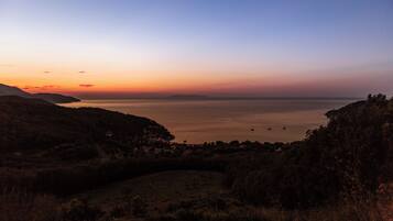 A coastal landscape with a view of the sea and distant hills.