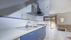 A modern kitchen with a white countertop, blue cabinets, and a stainless steel sink. - Il Porto Monolocale 4 (Porto Azzurro)