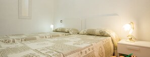 A bedroom with a bed, bedside table, and lamp.