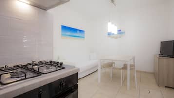 Apartamento, 2 quartos (1) | Cozinha americana privada | Geladeira grande, cooktop, talheres/pratos/utensílios de cozinha