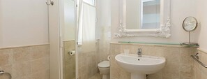 A bathroom with a white sink, a glass shelf, a mirror, and a toilet. - Appartamenti Rio Marina (Rio)