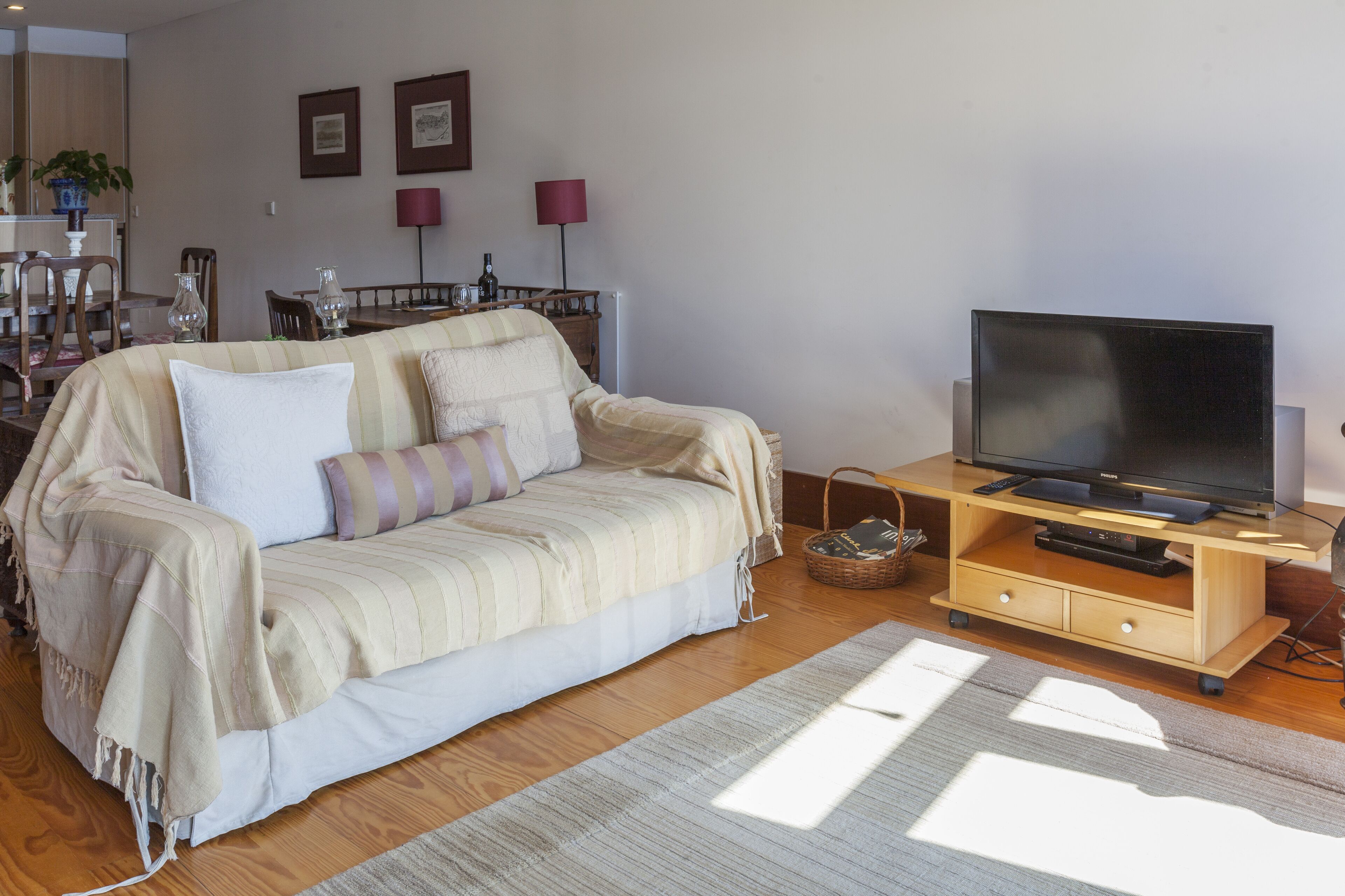 Un salon chaleureux avec un canapé, un meuble pour la télévision et un plancher en bois.