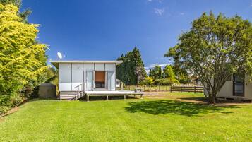 Enjoy a serene living area with a large glass door leading to a spacious interior and a deck for outdoor activities.