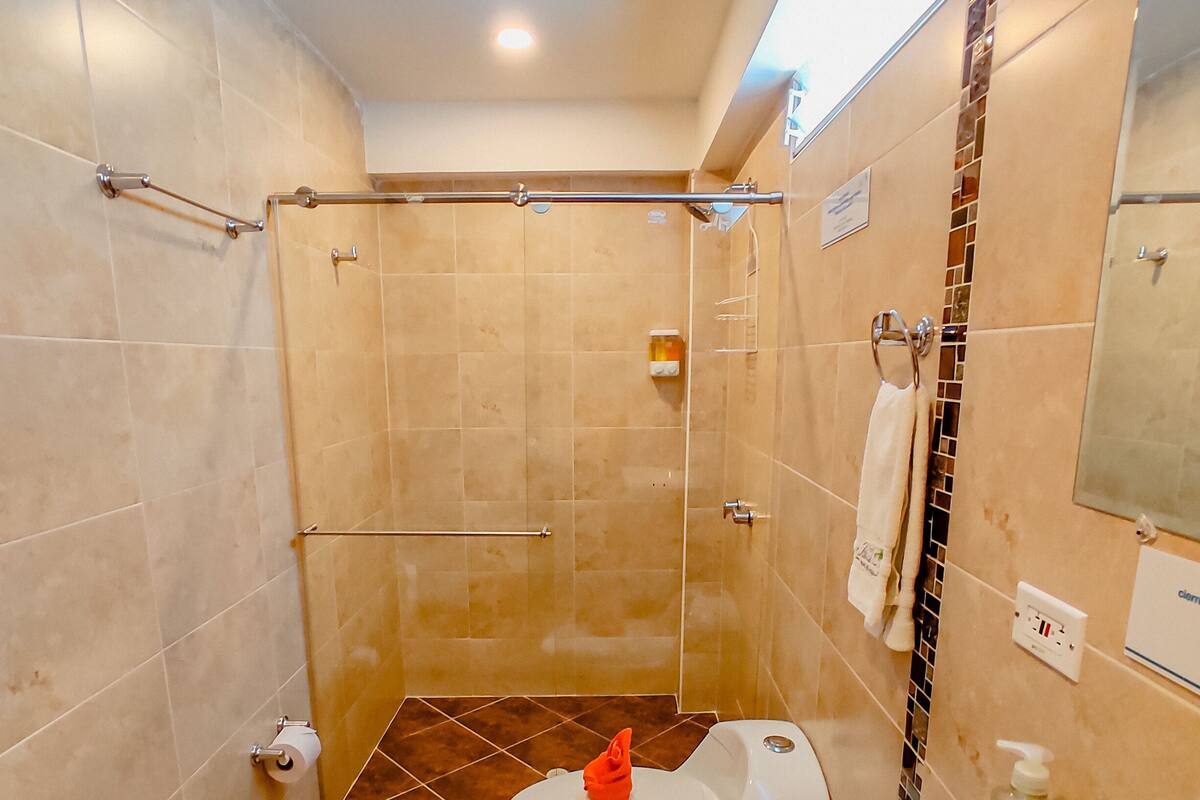 Un baño con ducha, inodoro y lavamanos.