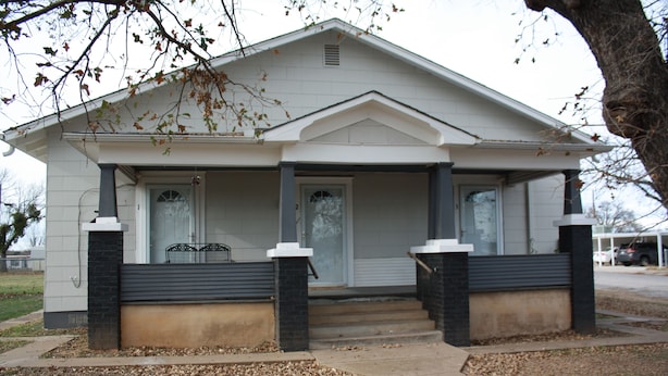 A single-story house with a front porch, a door, and a small window. - Cozy Efficiency near University and town (BROWNWOOD)