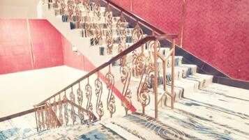 Una escalera con barandillas de metal decoradas y un suelo con diseño.