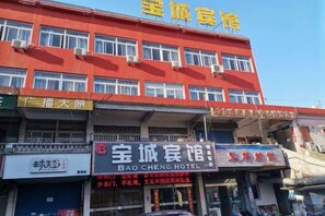 Un edificio de varios pisos con fachada roja y numerosas ventanas.