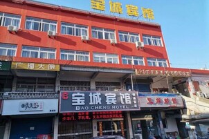 A multi-story building with a red facade and multiple windows.