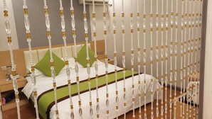 Ein Hotelzimmer mit Bett, Kissen, Nachttisch und einer Wand-Klimaanlage.