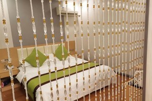 Une chambre d’hôtel équipée d’un lit, d’oreillers, d’une table de chevet et d’un climatiseur fixé au mur.