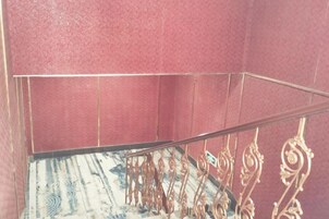 Una escalera con barandilla de metal y piso estampado.