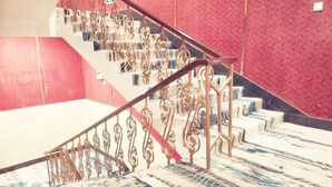 Eine Treppe mit aufwendiger Metallreling und gemustertem Teppich.