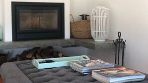 Un salon chaleureux avec une cheminée, une bibliothèque et un coin salon confortable.