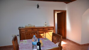 A dining area with a wooden table, chairs, a water bottle, and a wine bottle. - Casita del Pedregal  (Valle Gran Rey)