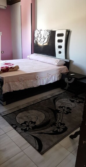 Cozy retreat with a floral-patterned bed and matching headboard, set against a stylish backdrop.